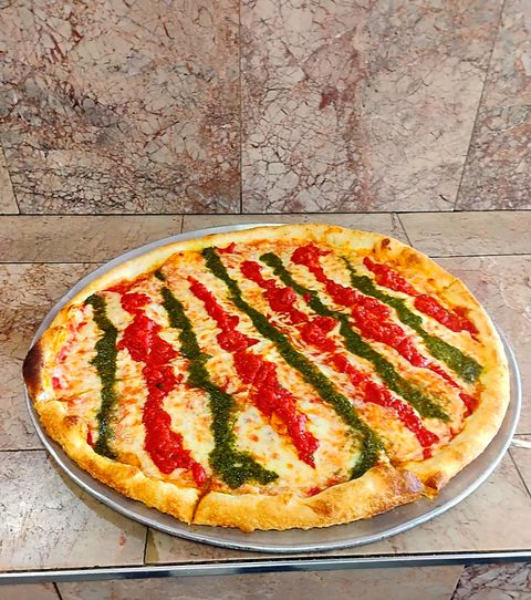Round pizza striped with red and green sauce